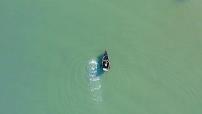 Isolated and unrecognizable fisherman rowing on small boat in calm sea or river waters, Dominican Republic. Aerial drone directly above