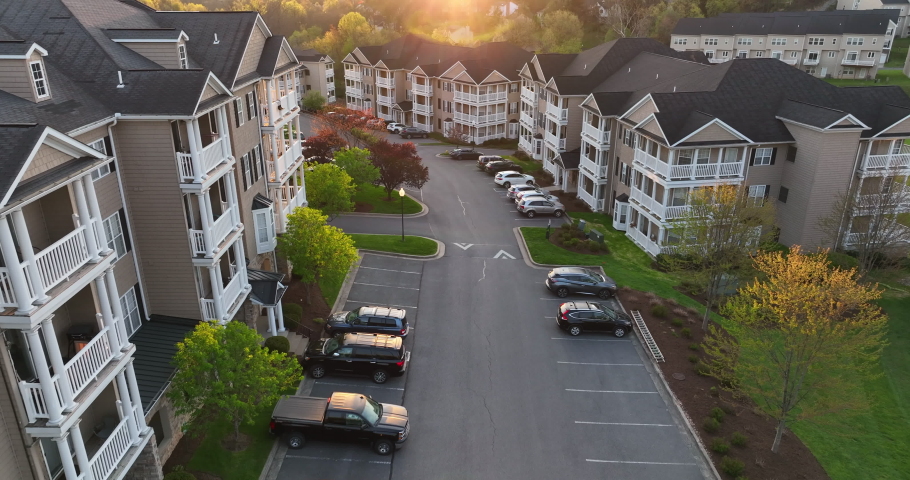 Cinematic aerial of residential apartment building USA at sunrise. New modern housing construction in America. Aerial view with starburst sun light effect. Royalty-Free Stock Footage #1089832905