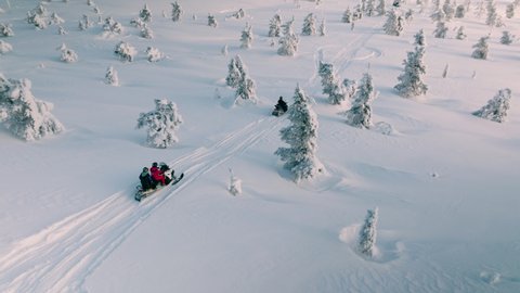 Tourists Riding Snowmobiles Through Thick Snow In Finland During Winter - aerial shot Stock Video