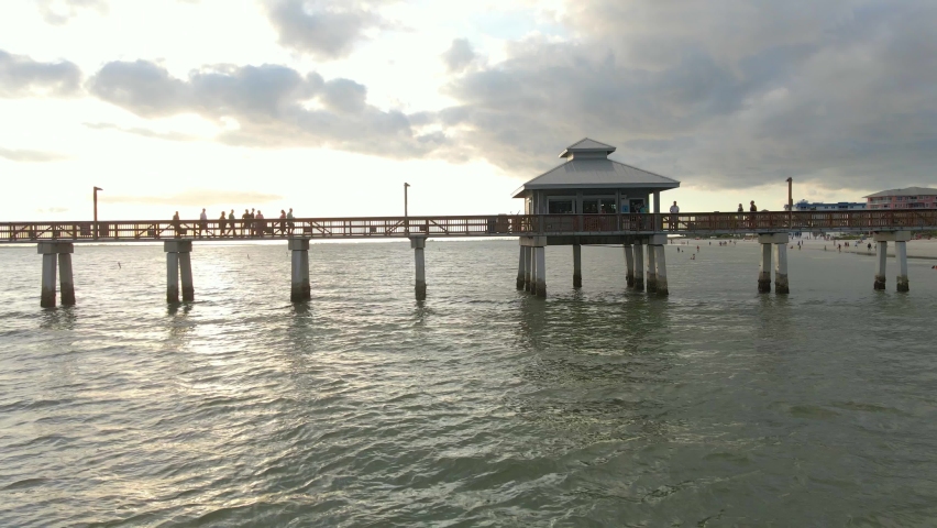 Aerial view people walking at Fort Myers iconic Pier during sunset, Florida