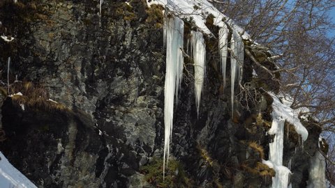 Big icicles hanging off a cliff face in the ice cold arctic