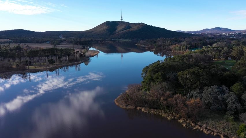 Stunning Canberra Lake Burley Griffin aerial moving forward, with cloud and Telstra Tower reflection in water