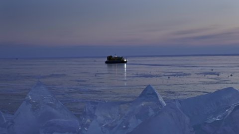 Sunset on frozen Lake Baikal landscape, ice ridges and hovercraft, 4k