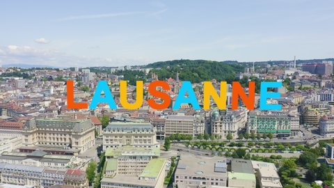 Inscription on video. Lausanne, Switzerland. Flight over the central part of the city. La Cite is a district historical centre. Different colors letters appears behind small squares, Aerial View
