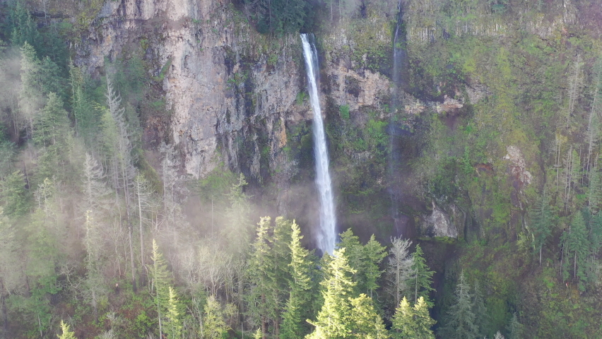 A scenic waterfall plunges over a 500 foot cliff into the Columbia River Gorge, Oregon. This beautiful canyon, with the Columbia River flowing through it, separates Oregon and Washington.