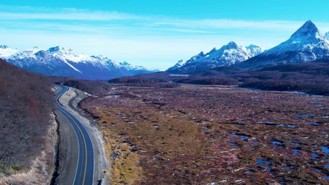 Patagonia road at Ushuaia Argentina, Tierra del Fuego. Stunning road between nevada mountains and colorful forest trees vegetation. Patagonia Argentina at Ushuaia Argentina. Patagonia landscape.