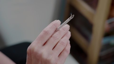 close-up white slim cigarette smokes in woman's hand