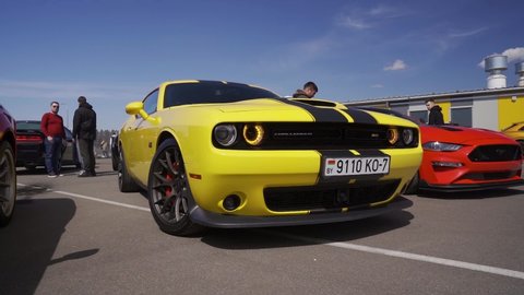 MINSK, BELARUS, May 1, 2022: Yellow Dodge Challenger car flashing headlights
