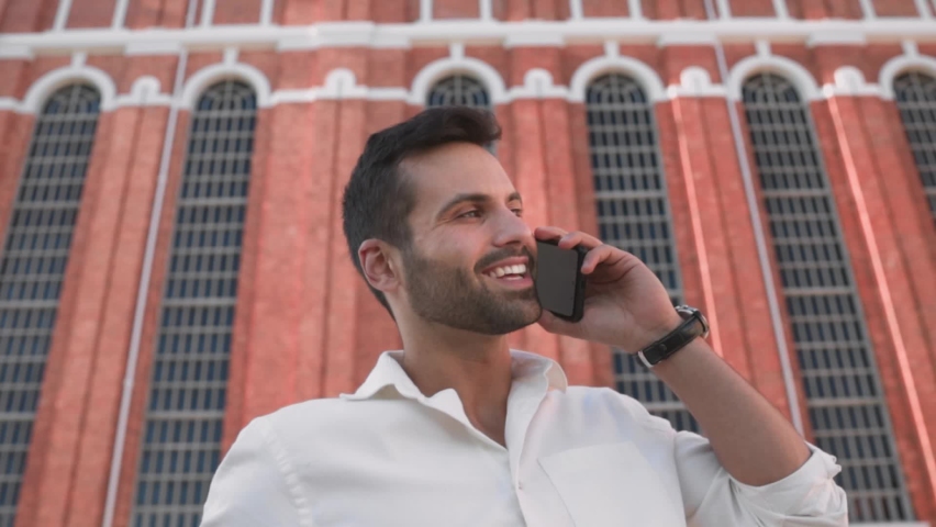 Handsome man talking on the phone with his business partner.