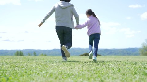 Parent and child running in the meadow