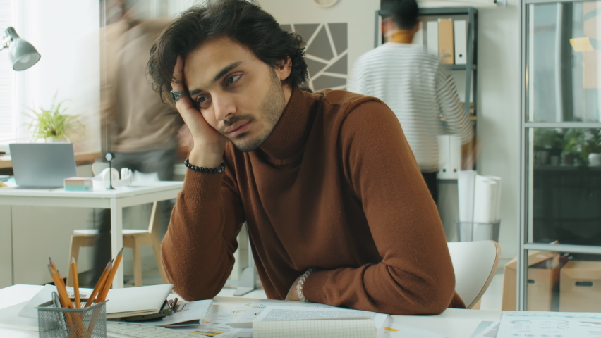 Time lapse of stressed middle eastern businessman resting head on hand and staring blankly while sitting at office desk during workday Royalty-Free Stock Footage #1089848343