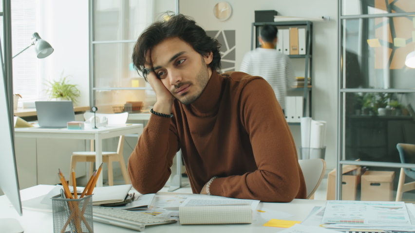 Time lapse of stressed middle eastern businessman resting head on hand and staring blankly while sitting at office desk during workday | Shutterstock HD Video #1089848343