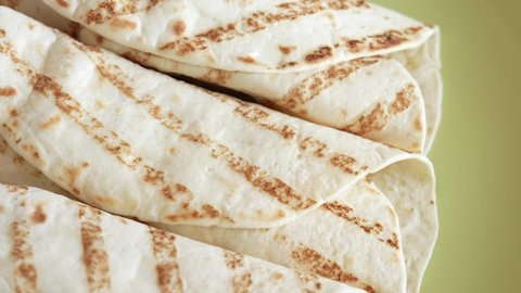 Closeup top view 4k stock video footage of tasty tortilla wraps stuffed with juicy meat with sauce. Wrapped sandwiches with grilled vegetables and meat pieces
