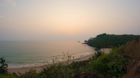 4K Wide angle time lapse of beach as seen from cliff above the Cabo De Rama beach at Goa in India. Time lapse of sunset at the beach. Nature Beach background. Summer holidays. Ocean wave background. 
