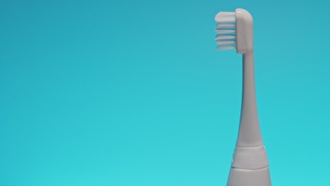 Electric ultrasonic toothbrush on shifting color background.
