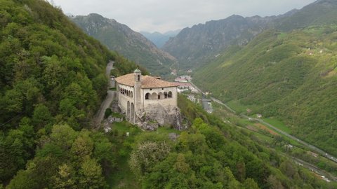 Aerial footage view from the drone of the Sanctuary of St. Patrick (San Patrizio) built on the sheer cliff, Colzate, Bergamo, Italy