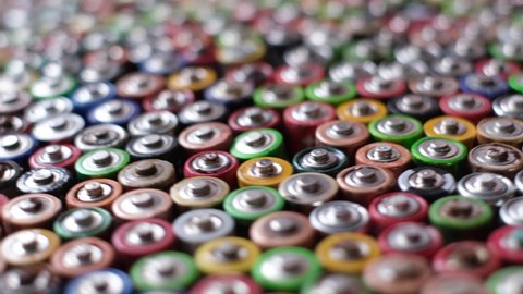 Background from moving AA rechargeable batteries. Many used alkaline batteries