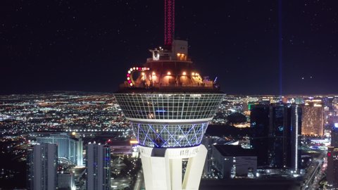 Breathtaking panoramic aerial around the STRAT hotel with attractions and rides on SkyPod observation deck with scenic views on night Las Vegas under stars. Stratosphere Tower, Las Vegas USA Apr. 2022