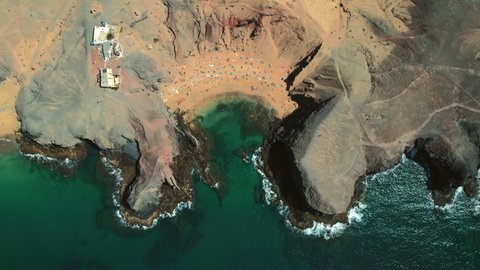 Drone point of view, directly above sandy beach of Lanzarote. People relax on most popular Papagayo beach of Lanzarote, cove of white sand, Atlantic Ocean bay, crystal clear, green water. Spain