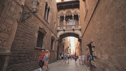 Barcelona, Spain - August 5, 2018: Bridge between buildings in Barri Gotic quarter of Barcelona, Spain. Old streets of Barrio Gotico in Barcelona, Catalonia. It is centre of old city of Barcelona