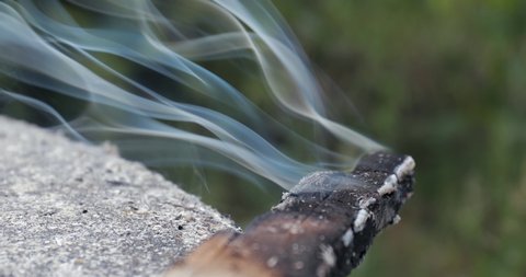 Burning wooden stick releasing smoke turning to ash, slow motion from 60fps footage