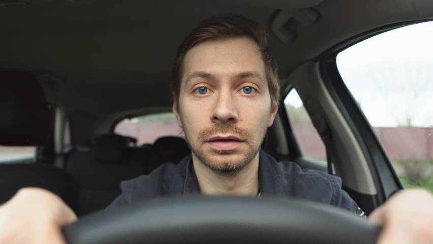 Young man driving a car shocked about to have traffic accident. Scared funny looking man driver in the car. Royalty-Free Stock Footage #1089857587