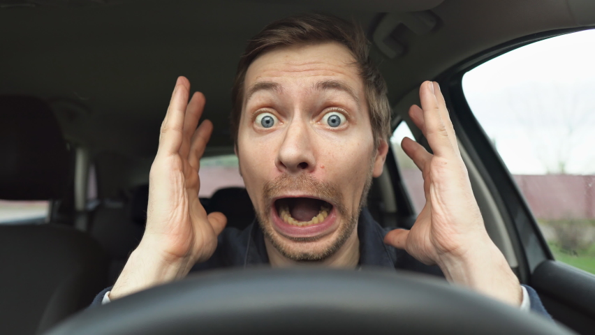 Young man driving a car shocked about to have traffic accident. Scared funny looking man driver in the car. | Shutterstock HD Video #1089857587