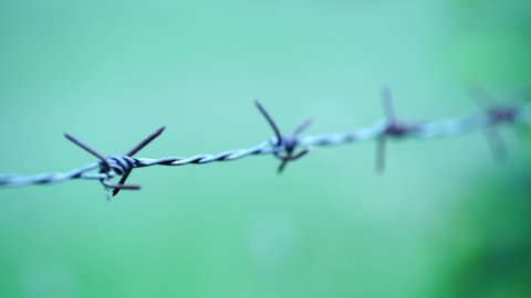 Close-up photo of rusted barbed wire fence sky background.soft focus.