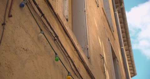 Low angle view of a cat sitting on a window ledge in the alleyways of Montpellier in France