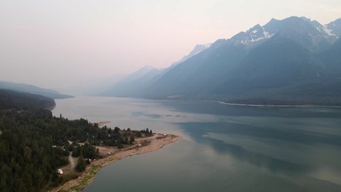 Beautiful landscapes of Kinbasket Lake and the Rocky Mountains during wildfires near Canoe Reach in Valemount, British Columbia, Canada. Wide angle aerial shot 