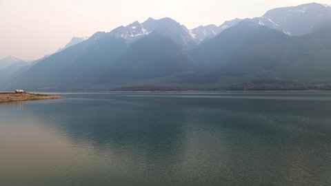 Stunning Rocky Mountains bordering Kinbasket Lake during wildfires near Canoe Reach in Valemount, British Columbia, Canada. Wide angle aerial shot 