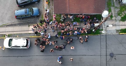 Morgantown , WV , United States - 04 29 2022: Group of students at outdoor frat party. College university social life with dressed up guys and girls drinking beer. Aerial top down view.