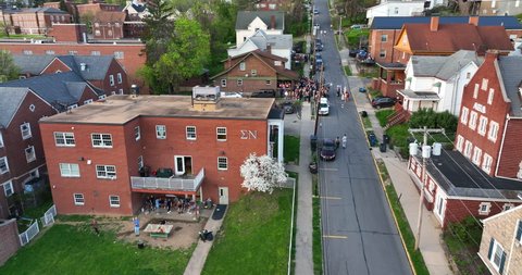 Morgantown , WV , United States - 04 29 2022: Greek row with frats and sororities at West Virginia University, WVU. Students drink at keg party and play games. Aerial view.