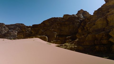 Sand Dunes And Rock Formations In Wadi Rum Protected Area, UNESCO World Heritage Site In Jordan. aerial pan left