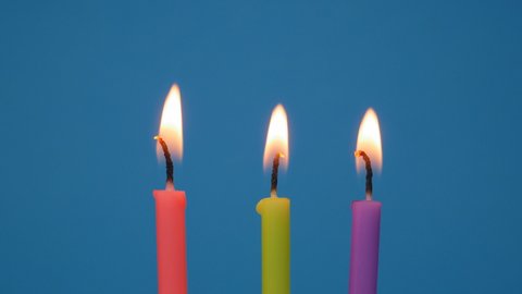 Lighted candles in a birthday cake on a blue background.Close up colorful flame candles in a homemade cake. birthday candles for home party