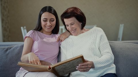 Mother and daughter looking at photo album together