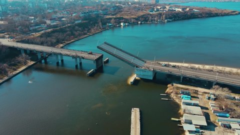 Lowering of upper part drawbridge over the river Nikolaev Ukraine few days before start of armored invasion. Logistics concept of water cargo transportation