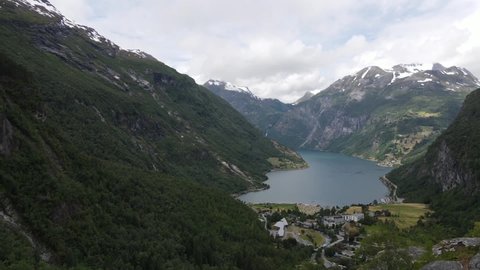 Panoramic drone footage from Geirangerfjord in Summer, majestic landscape with snow covered mountain tops. Nature aerial drone video with lush vegetation in Geiranger, Norway