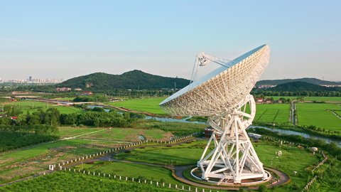 Aerial footage of astronomical radio telescope and beautiful sky clouds at sunset. Radio telescopes are used in science for space observation and distant objects exploring.