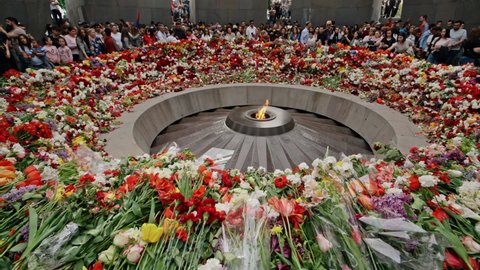 Armenia, Yerevan, The Armenian Genocide Memorial, April 24, 2022 -Inside the crowded Armenian Genocide Memorial. People laying flowers arround the eternal flame. Tilt shot