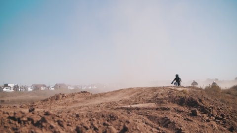 Skilled motocross rider on a sandy track, performing stunts on motorcycles, moto festival, slow motion