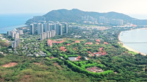 Aerial footage of beautiful city skyline and mountain with sea natural scenery in Hainan Island, China. 