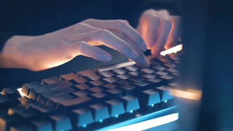 Programmer writes code on computer keyboard