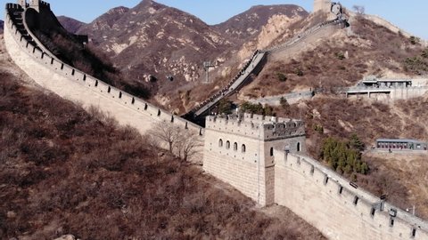 Aerial orbiting view of tower at Great Wall of China, clip taken in early spring. Badaling section of wall, stone fortification running up and down on mountain slopes
