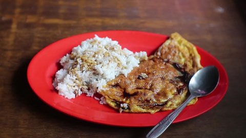 Traditional way of eating fried omelet and rice with hand compliment with sweet soy sauce