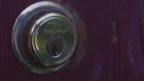 A Man Unlocks a Door.