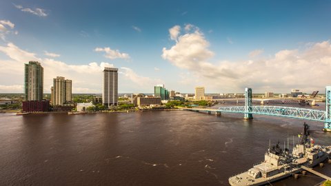 Jacksonville, Florida - April 7, 2022: A Timelapse of clouds rolling across the St. Johns River in Downtown Jacksonville, Florida while boats race around the water and traffic crosses the bridges.