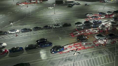 Tesla factory, Fremont, USA. Feb. 2022. EV sedans loaded on a carriages after testing as seen from above. Aerial footage of brand new energy efficient cars at the parking lot. High quality 4k footage