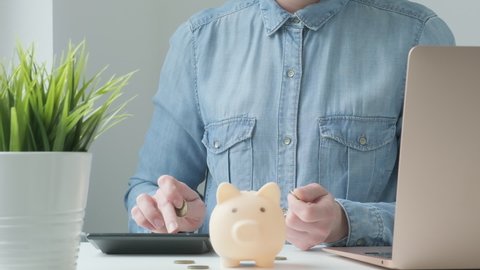 Woman putting coins in piggy bank. Female saving money for utility bills, household payments, calculating monthly family budgets, making investments or strategy for personal savings for the future