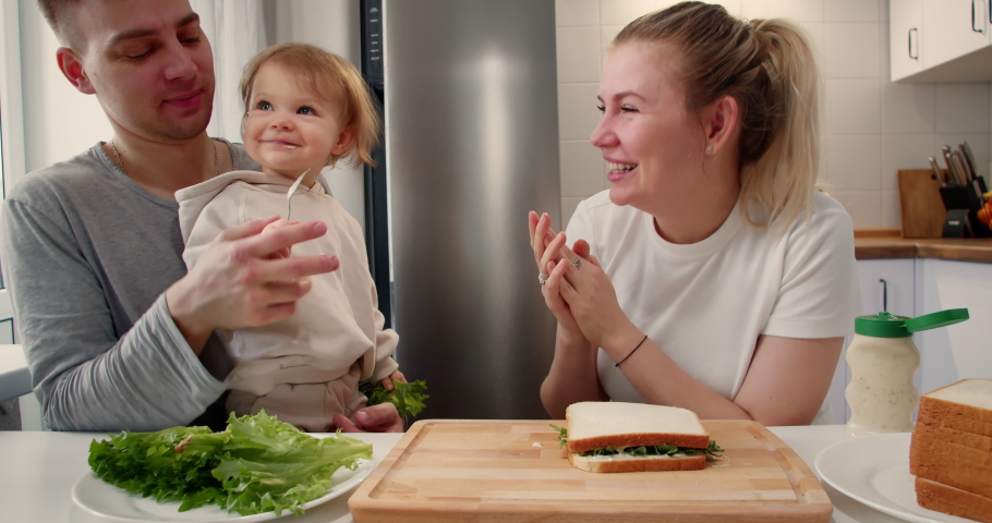 Happy smiling family is enjoying their time together while having a breakfast in a kitchen at home in the morning.